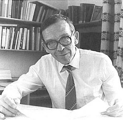 Hans-Jürgen Matthies, Gründer des IfN, sitzt am Schreibtisch und lächelt in die Kamera.